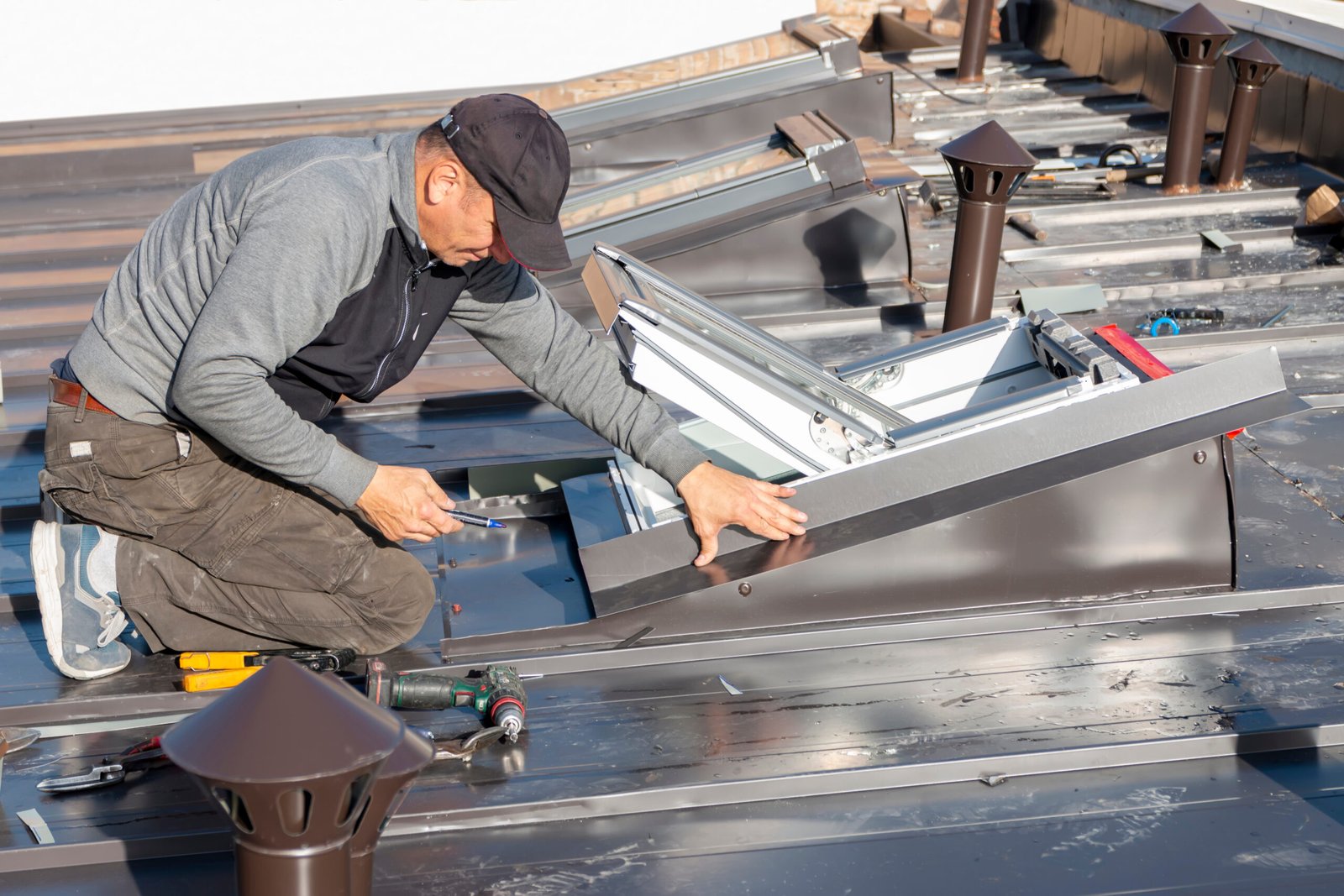 A professional roofer in Ajax covers the roof window with sheet metal.