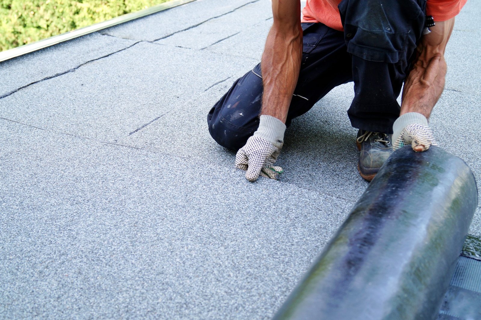 Roofer installing tar foil on the rooftop of building. Flat roof installation in Ajax, On